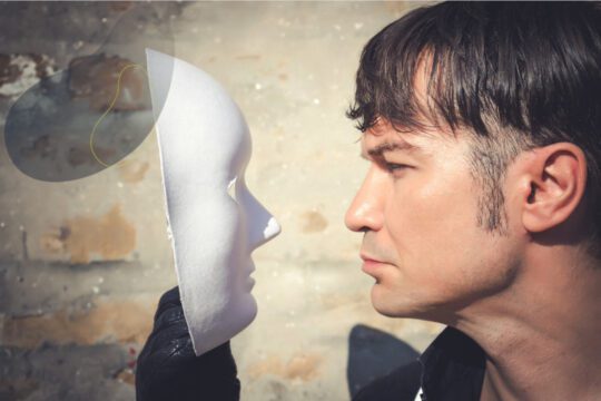 Mężczyzna patrzący na maskę symbolizującą dialog wewnętrzny i wewnętrzną rozmowę z samym sobą