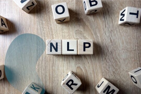 Klocki drewniane układające się w napis NLP, ilustracja do artykułu o neurolingwistycznym programowaniu.
