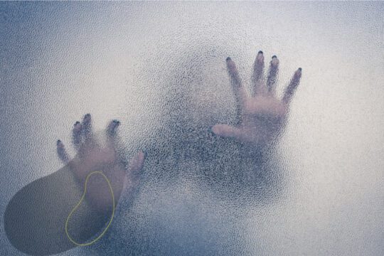 Sylwetka osoby widoczna za matową szybą jako metafora lęku uogólnionego