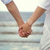 Para trzymająca się za ręce podczas spaceru nad morzem - symbol odbudowy zaufania w relacj