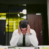 Mężczyzna doświadczający kryzysu finansowego i przeciążenia decyzyjnego w pracy