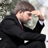 Mężczyzna w kryzysie finansowym siedzący w zamyśleniu, doświadczający napięcia i poczucia utraty kontroli