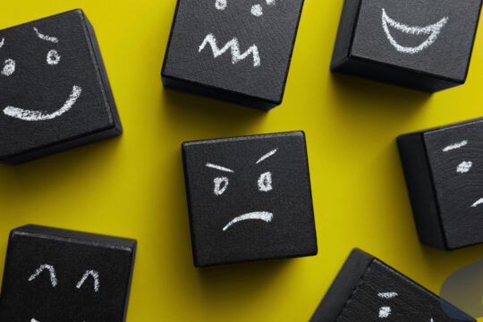 Kostki z narysowanymi różnymi wyrazami twarzy symbolizujące regulację emocji