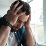 Lęk antycypacyjny – mężczyzna trzymający głowę w dłoniach podczas zamartwiania się przyszłością